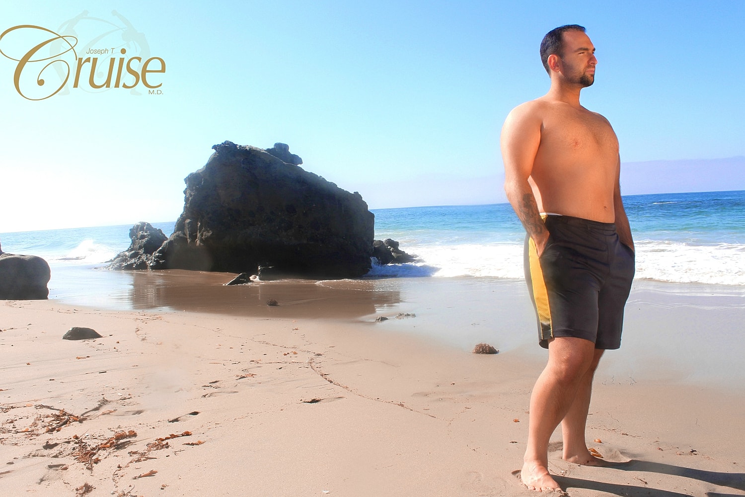 Man standing on beach with rocks and ocean.