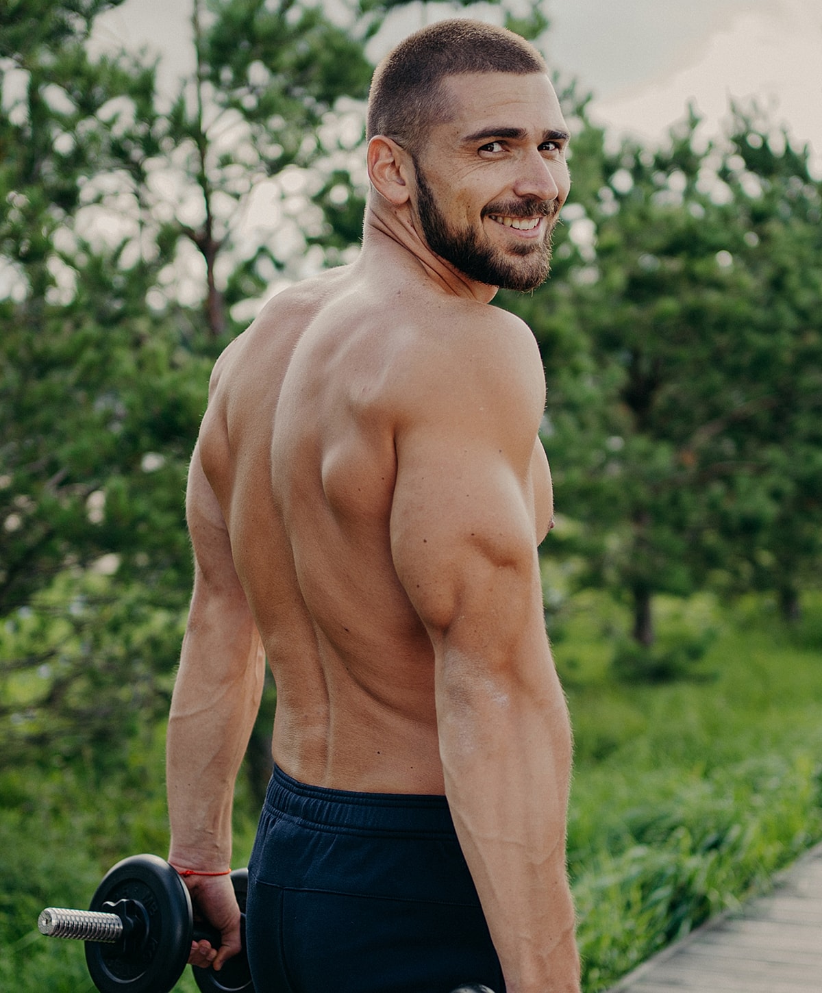 Man grooming himself in bathroom mirror reflection.