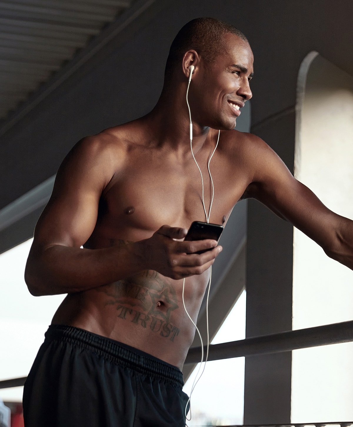 Man listening to music while holding smartphone.