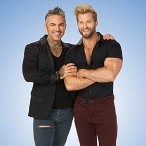 Two smiling men posing together.