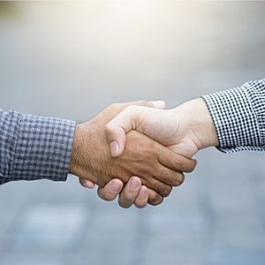 Two hands shaking in partnership or agreement.