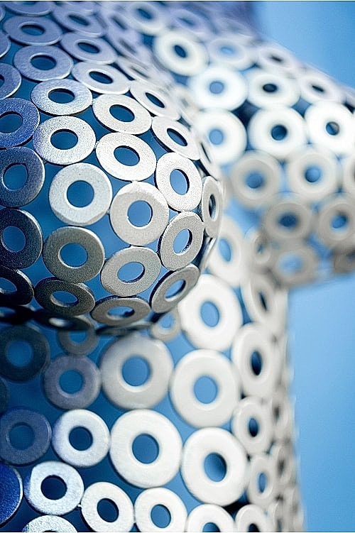 Metallic sculpture covered in circular patterns.