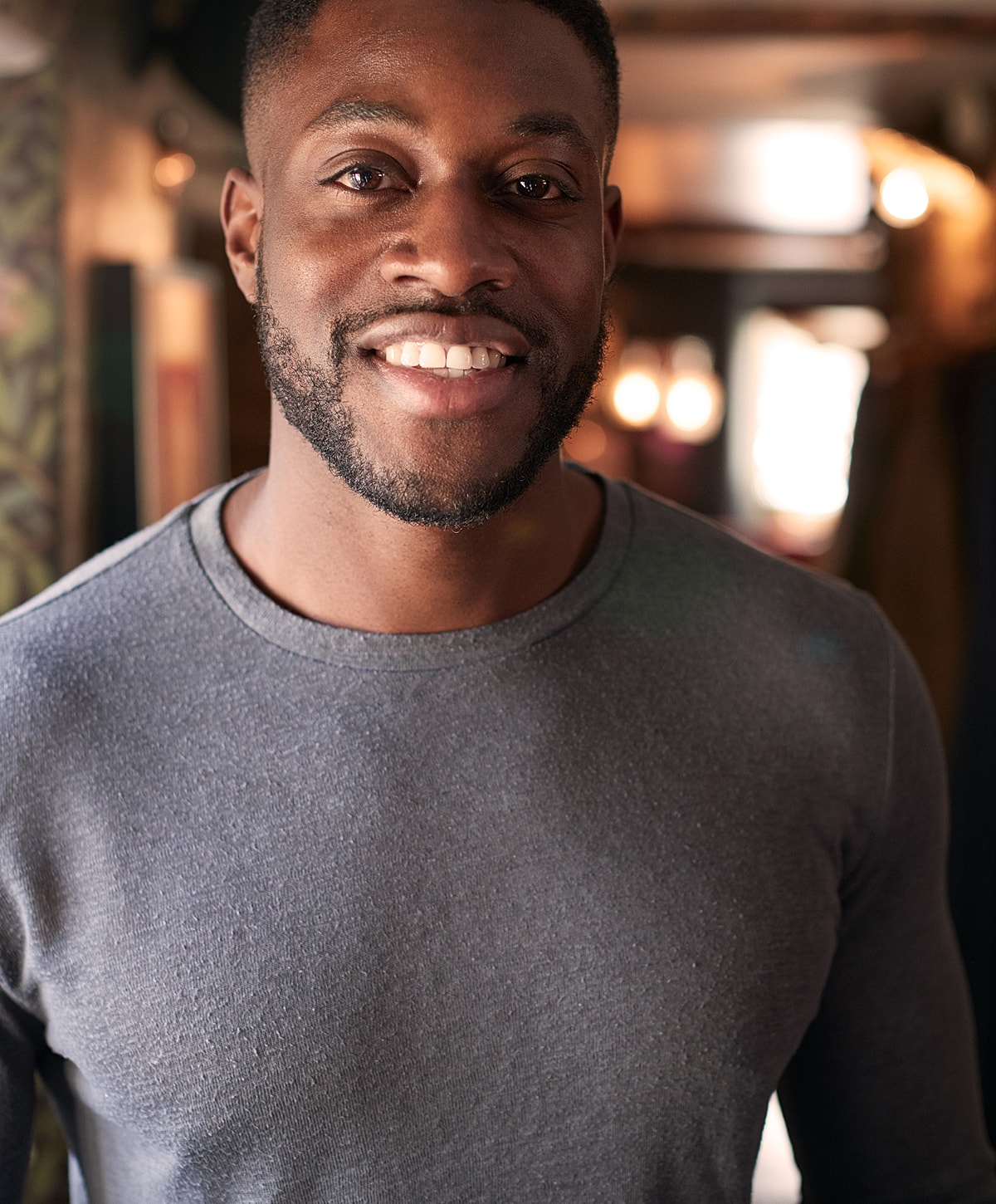 Doctor in scrubs smiling in a surgical setting.