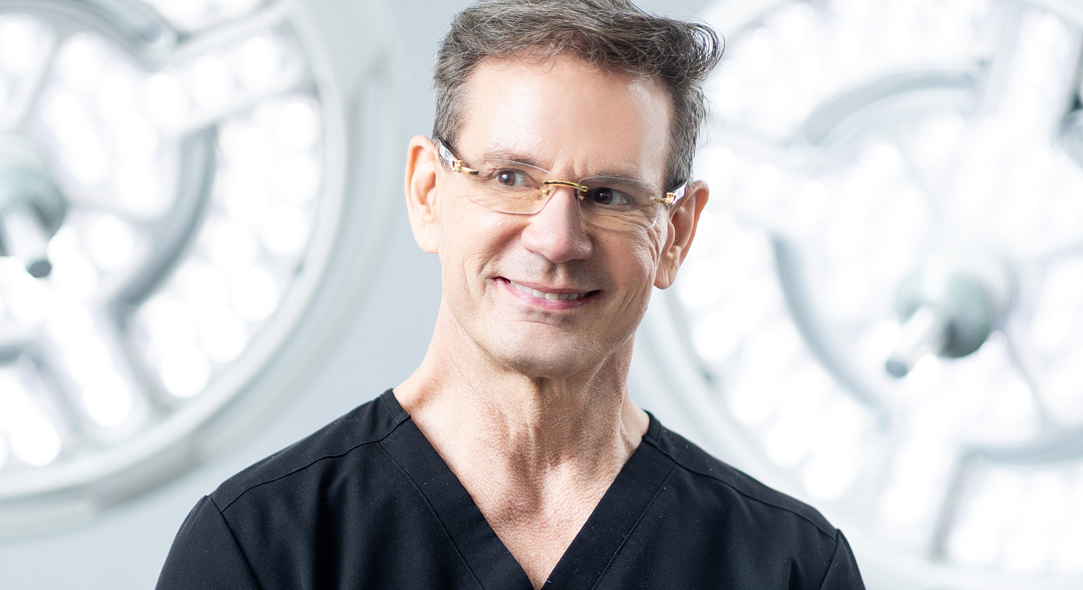 Smiling medical professional in surgical environment.