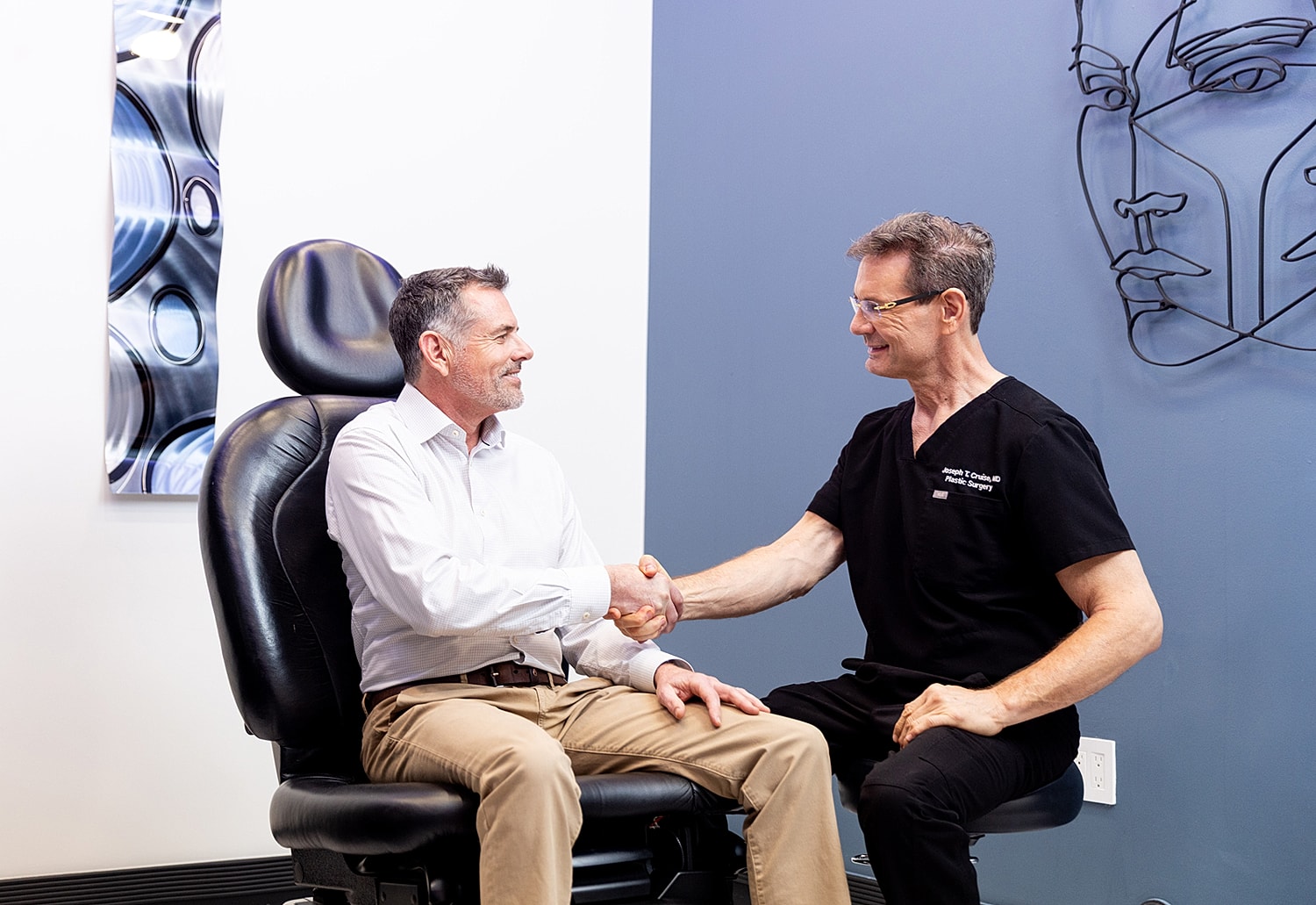 Man handing over a tablet to another person.