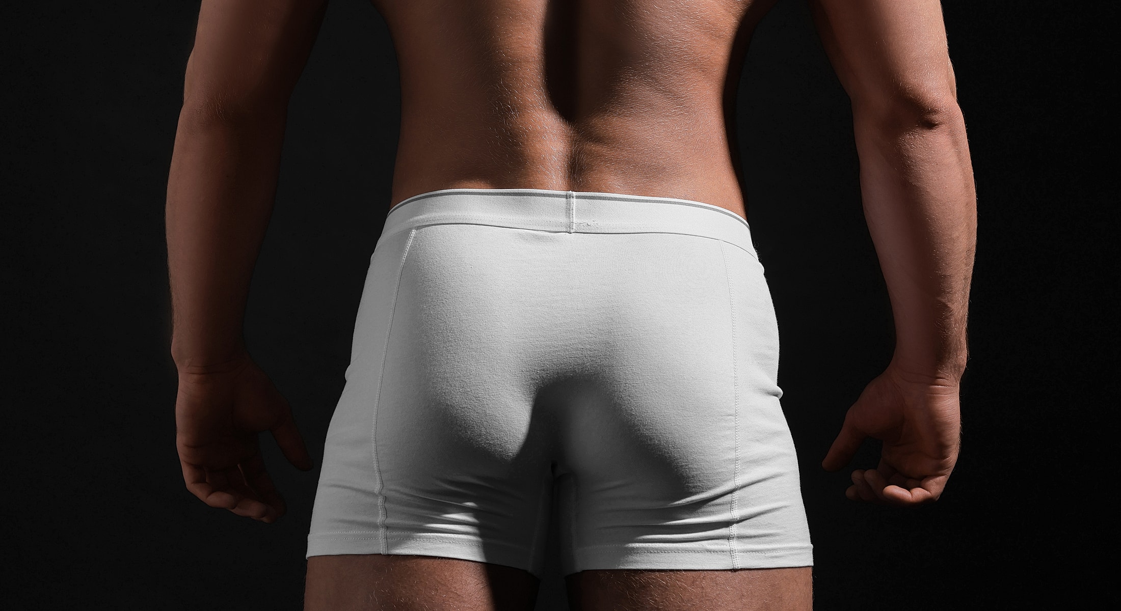 Male model from behind wearing white shorts.