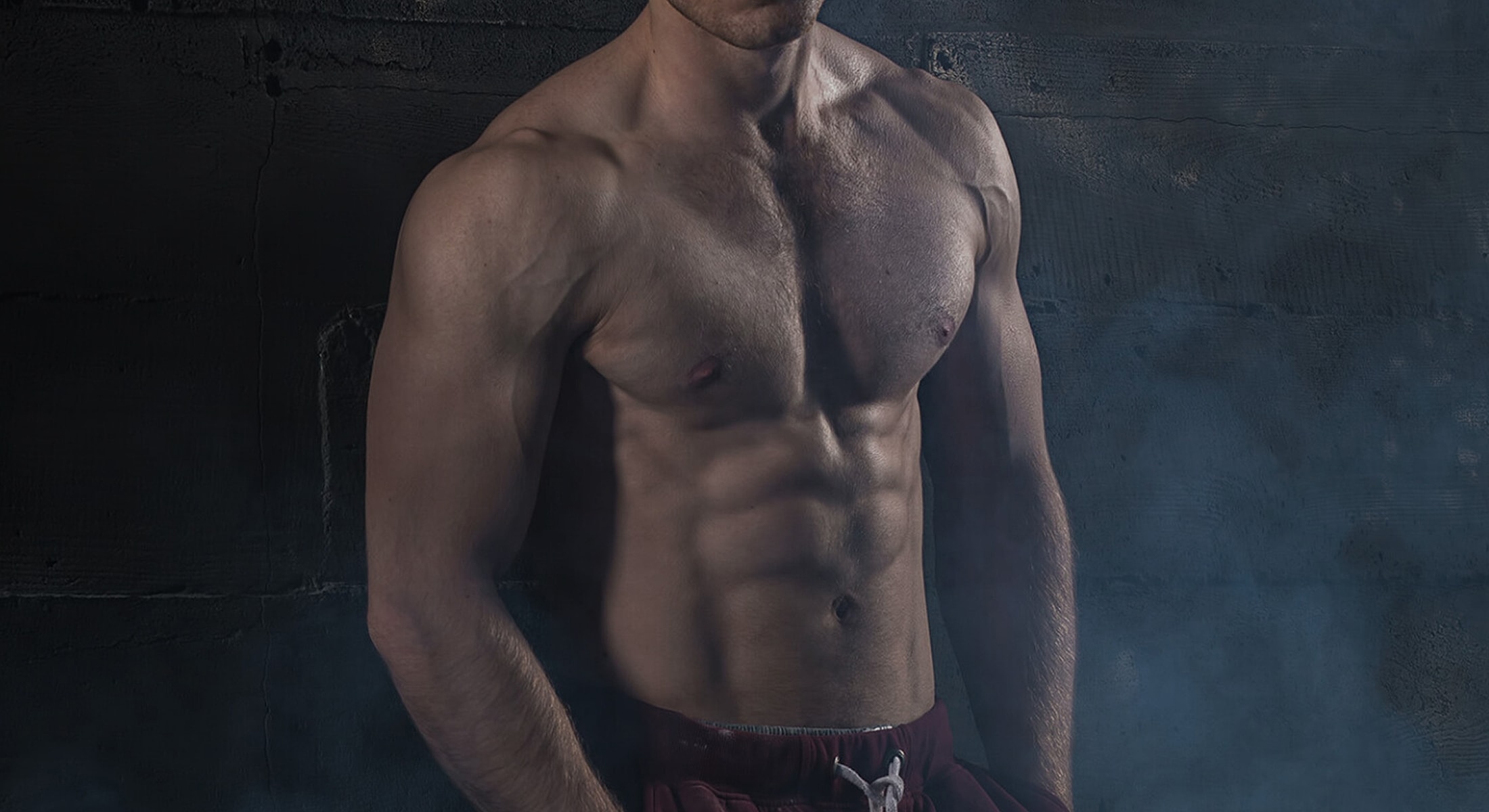 Muscular man posing in a dramatic setting